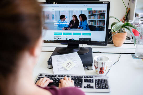 Blick über die Schulter einer frau auf die Webseite von vlb.de.