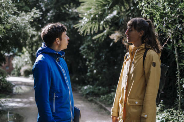 Mann (rechts) und Frau (links) unterhalten sich im tropischen Wald.