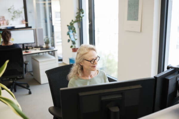 Eine Frau sitzt an einem Schreibtisch.