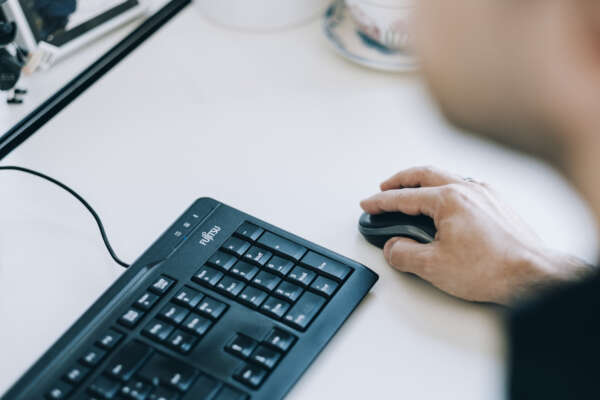 Hand an Maus neben Tastatur