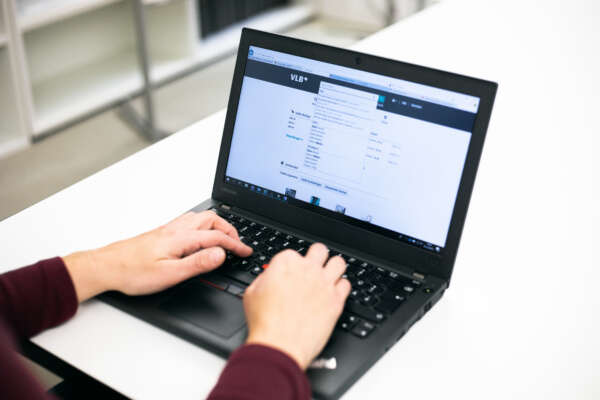 Hände auf Laptop-Tastatur.