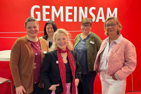 Fünf Frauen am Stand des Börsenvereins vor einer roten Wand mit der Aufschrift Gemeinsam.